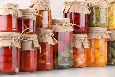 Photo of Many jars with different pickled products on light table