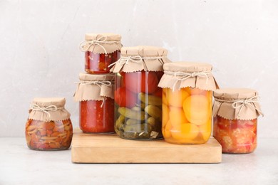 Photo of Many jars with different pickled products on light table