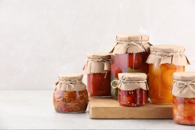 Photo of Many jars with different pickled products on light table. Space for text