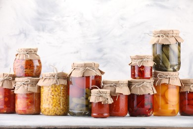 Photo of Many jars with different pickled products on light table. Space for text