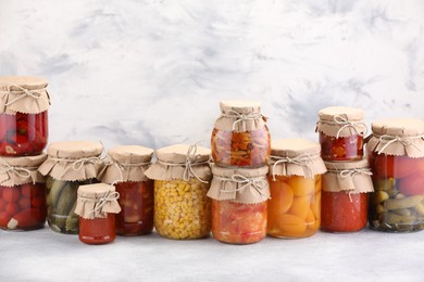 Photo of Many jars with different pickled products on light table. Space for text