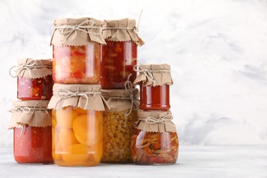 Photo of Many jars with different pickled products on light table. Space for text