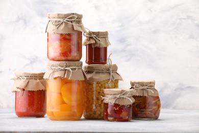Photo of Many jars with different pickled products on light table. Space for text