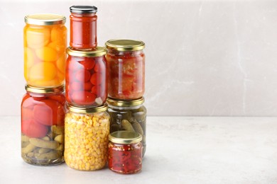 Photo of Many jars with different pickled products on light table. Space for text