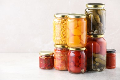 Photo of Many jars with different pickled products on light table. Space for text