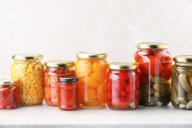 Photo of Many jars with different pickled products on light table. Space for text