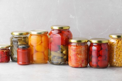 Photo of Many jars with different pickled products on light table