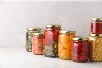 Photo of Many jars with different pickled products on light table. Space for text