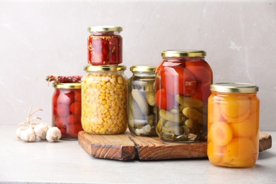 Photo of Many jars with different pickled products on light table