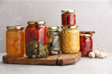 Photo of Many jars with different pickled products on light table