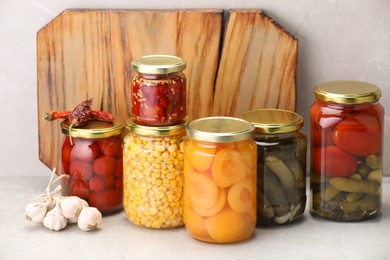 Photo of Many jars with different pickled products on light table
