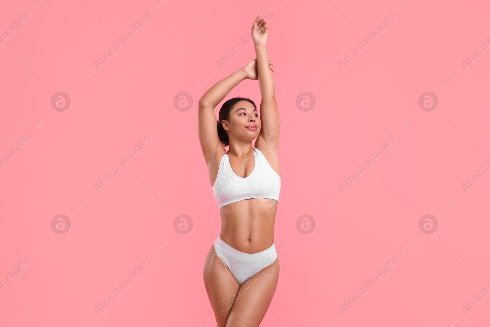 Woman in white underwear with smooth skin after epilation procedure on pink background Photo of Woman in white underwear with smooth skin after epilation procedure on pink background