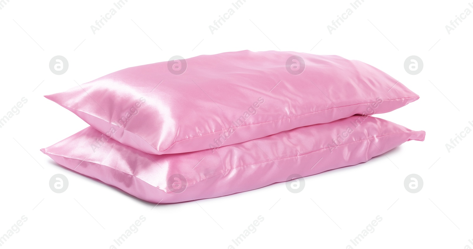 Pillows in pink pillowcases isolated on white. Silk bed linens Photo of Pillows in pink pillowcases isolated on white. Silk bed linens