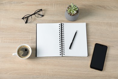 Photo of Flat lay composition with office supplies and cup of coffee on wooden table