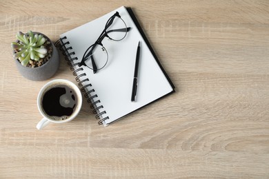 Photo of Flat lay composition with office supplies and cup of coffee on wooden table. Space for text