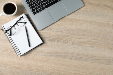 Photo of Flat lay composition with office supplies, laptop and cup of coffee on wooden table. Space for text