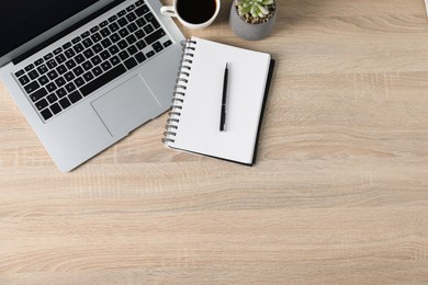 Photo of Flat lay composition with office supplies, laptop and cup of coffee on wooden table. Space for text