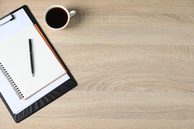 Photo of Office supplies and cup of coffee on wooden table, flat lay. Space for text