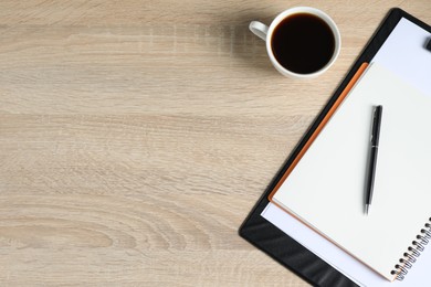 Photo of Office supplies and cup of coffee on wooden table, flat lay. Space for text