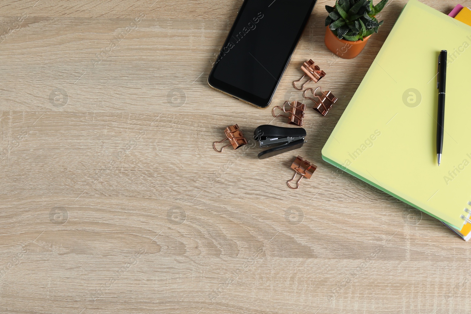Flat lay composition with office supplies, smartphone and houseplant on wooden table. Space for text Photo of Flat lay composition with office supplies, smartphone and houseplant on wooden table. Space for text