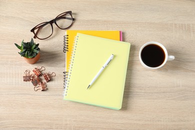 Photo of Flat lay composition with office supplies, cup of coffee and houseplant on wooden table