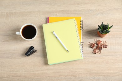 Photo of Flat lay composition with office supplies, cup of coffee and houseplant on wooden table