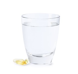 Photo of Collagen capsules and glass of water isolated on white