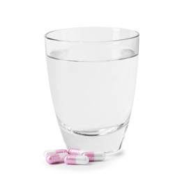Photo of Collagen capsules and glass of water isolated on white
