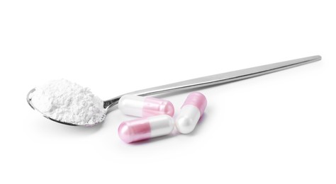 Photo of Collagen powder in spoon and pills isolated on white