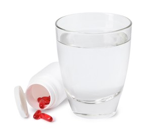 Photo of Collagen capsules in bottle and glass of water isolated on white