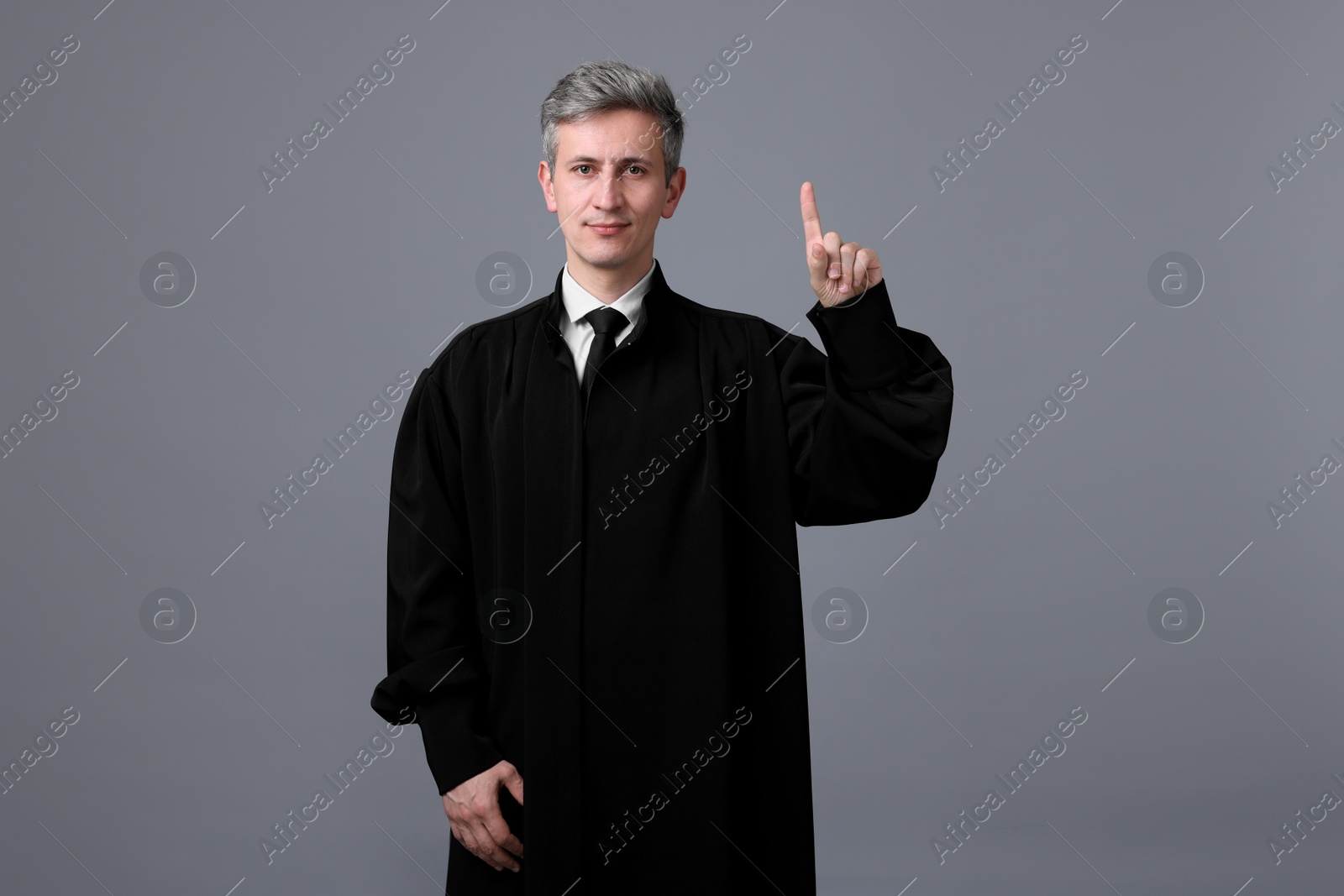 Judge in court dress shaking finger on grey background Photo of Judge in court dress shaking finger on grey background
