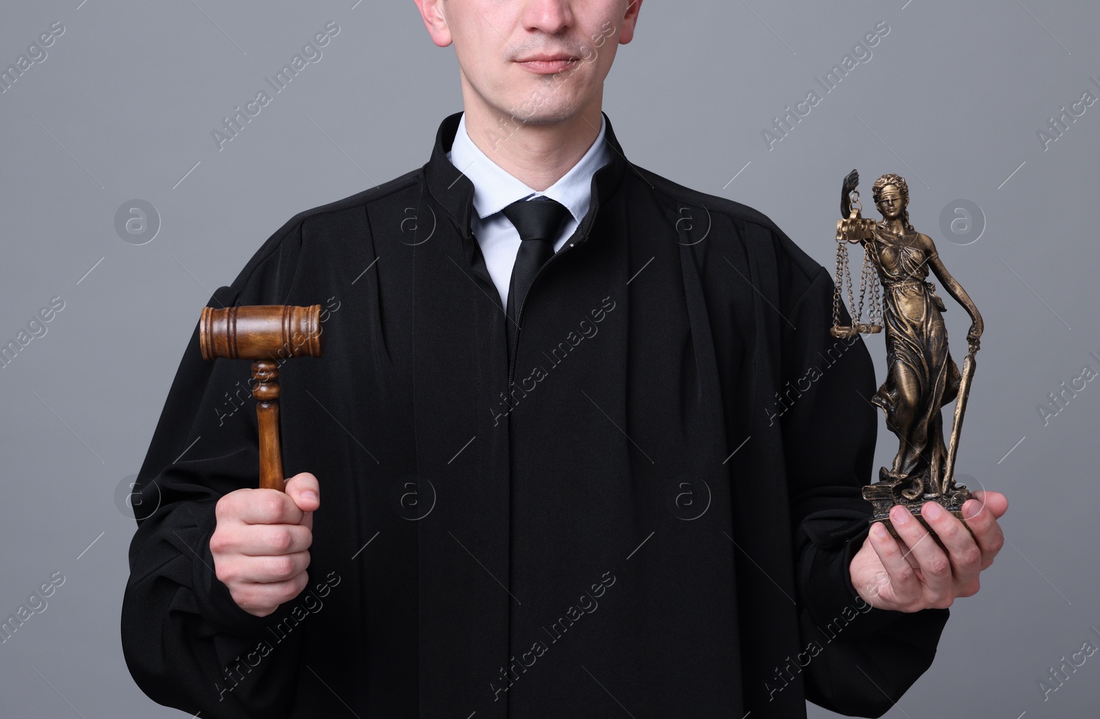 Judge with mallet and statue of Lady Justice on grey background, closeup Photo of Judge with mallet and statue of Lady Justice on grey background, closeup