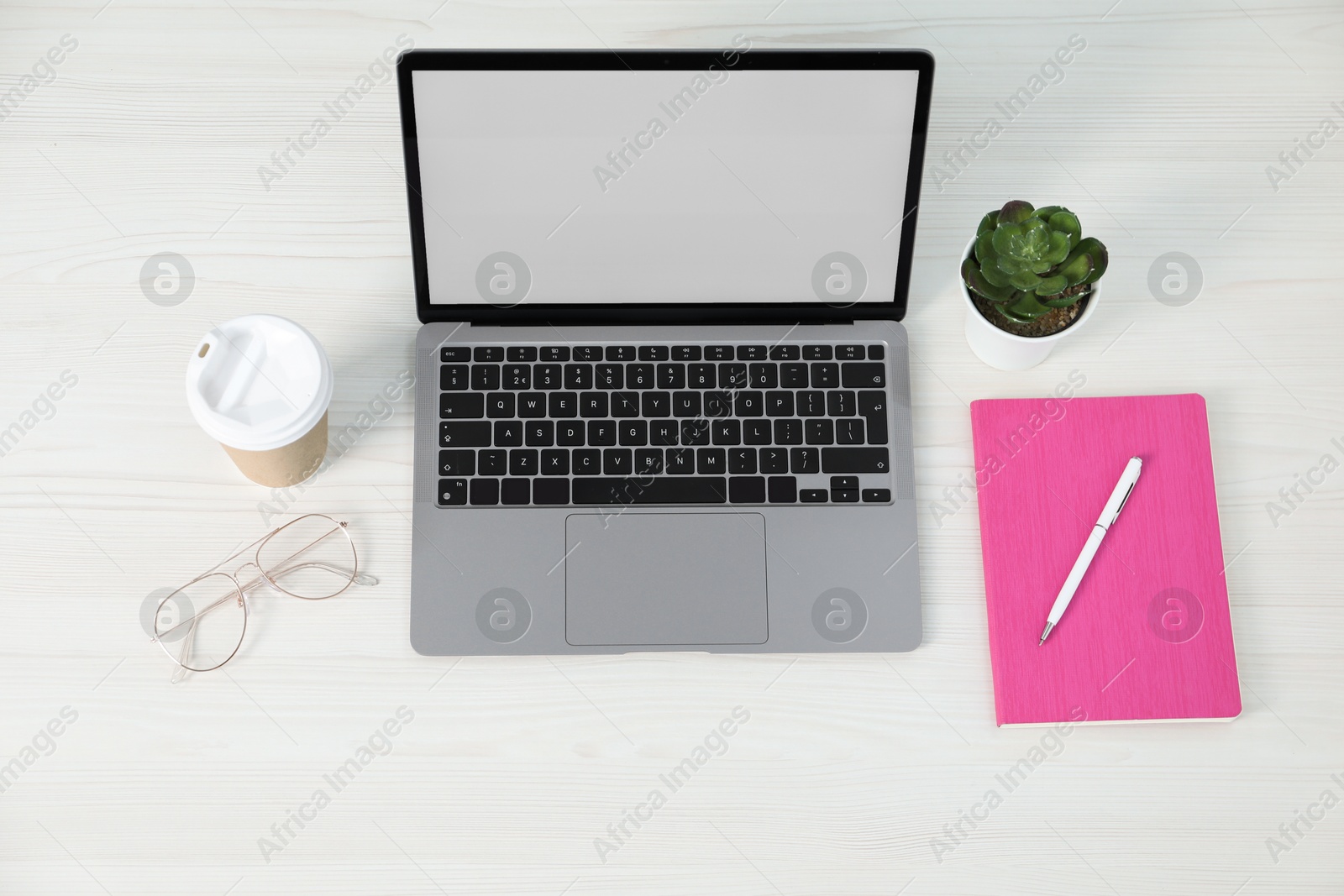 Office supplies, laptop, houseplant and takeaway paper cup on light wooden table, above view Photo of Office supplies, laptop, houseplant and takeaway paper cup on light wooden table, above view