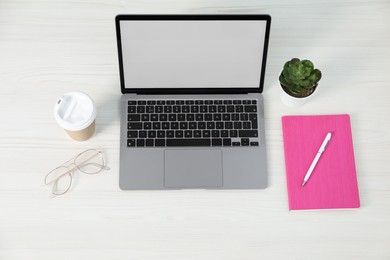 Photo of Office supplies, laptop, houseplant and takeaway paper cup on light wooden table, above view