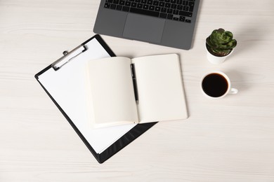 Photo of Flat lay composition with office supplies, laptop, cup of coffee and houseplant on light wooden table