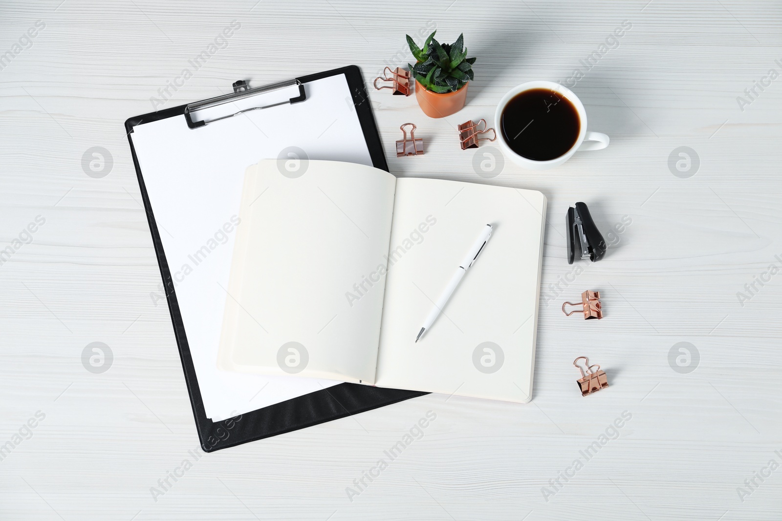 Flat lay composition with office supplies, cup of coffee and houseplant on white wooden table Photo of Flat lay composition with office supplies, cup of coffee and houseplant on white wooden table