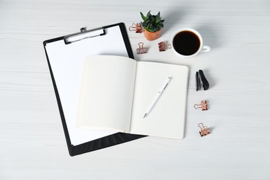 Photo of Flat lay composition with office supplies, cup of coffee and houseplant on white wooden table