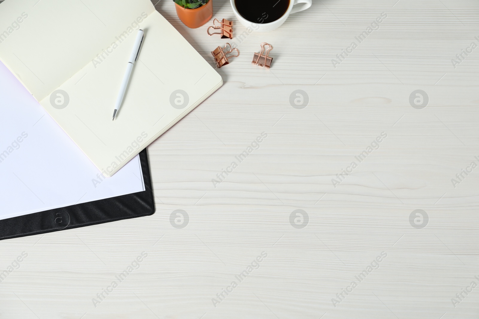 Flat lay composition with office supplies and cup of coffee on light wooden table. Space for text Photo of Flat lay composition with office supplies and cup of coffee on light wooden table. Space for text