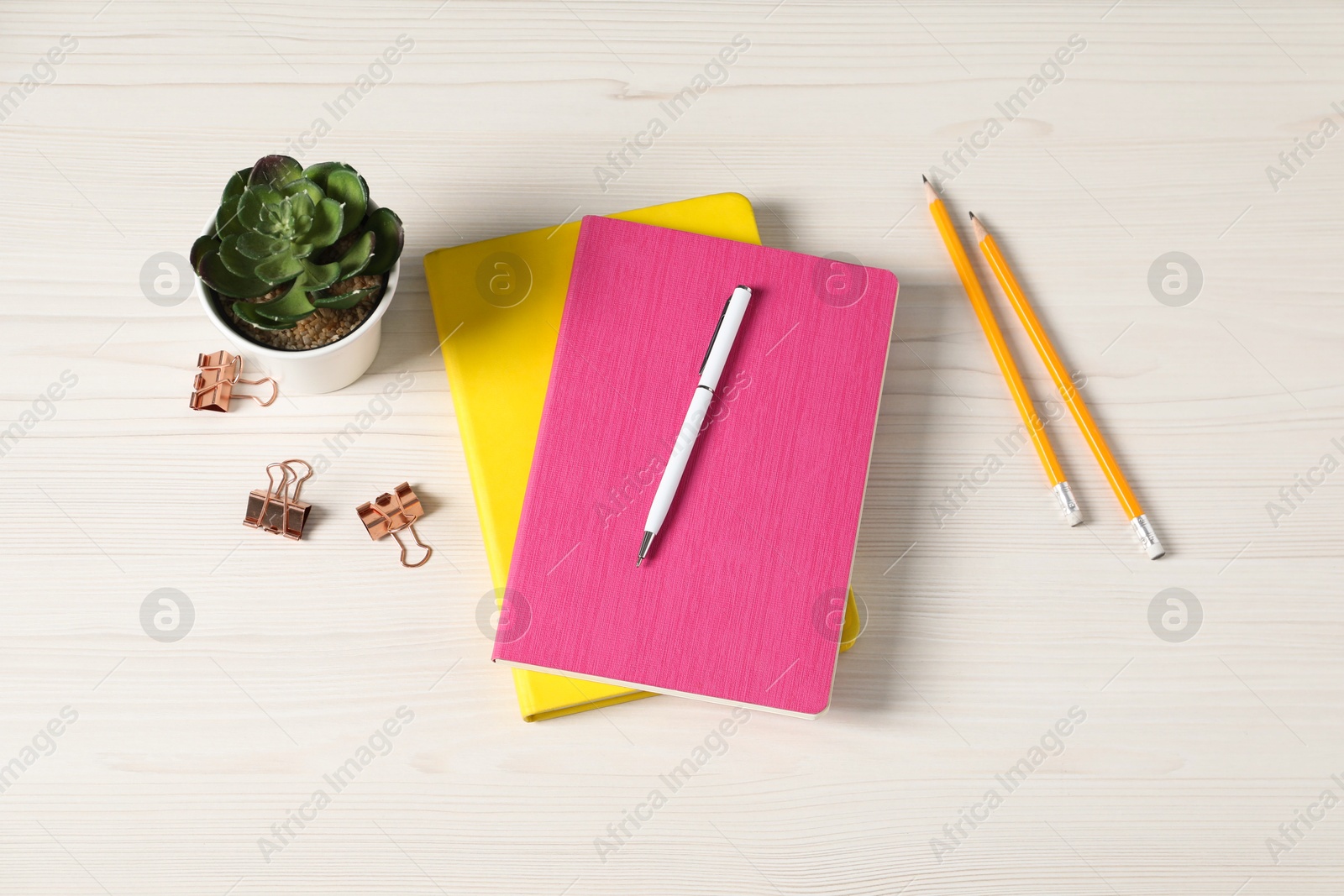 Flat lay composition with office supplies and houseplant on light wooden table Photo of Flat lay composition with office supplies and houseplant on light wooden table