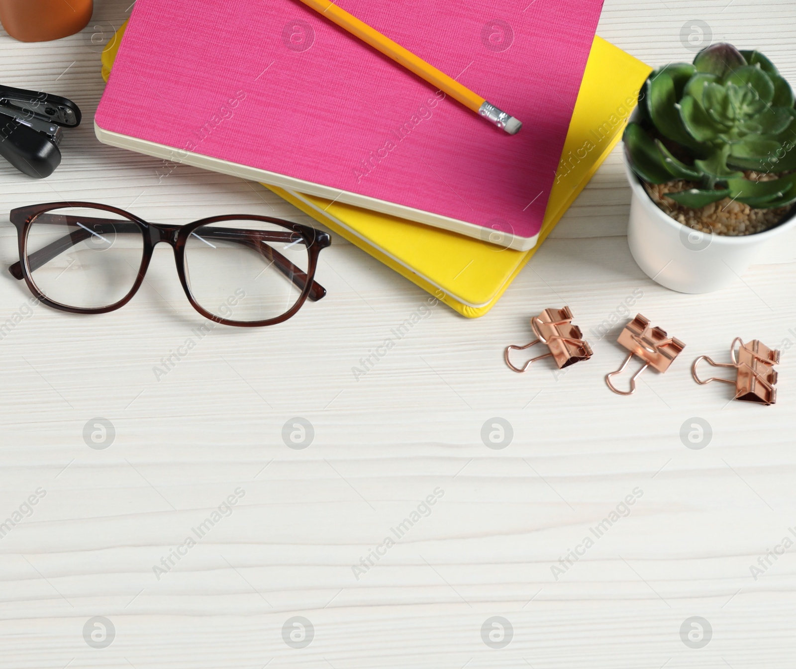 Flat lay composition with office supplies and houseplant on light wooden table. Space for text Photo of Flat lay composition with office supplies and houseplant on light wooden table. Space for text