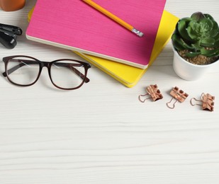 Photo of Flat lay composition with office supplies and houseplant on light wooden table. Space for text