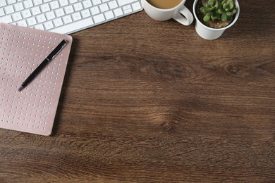 Photo of Flat lay composition with office supplies and houseplant on wooden table. Space for text
