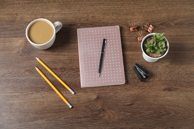 Photo of Flat lay composition with office supplies, cup of coffee and houseplant on wooden table