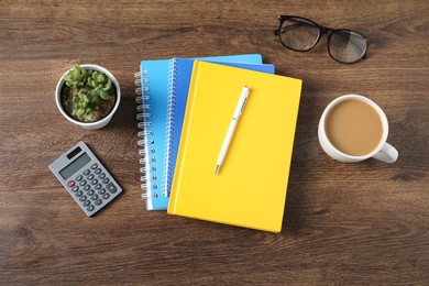 Photo of Flat lay composition with office supplies, cup of coffee and houseplant on wooden table