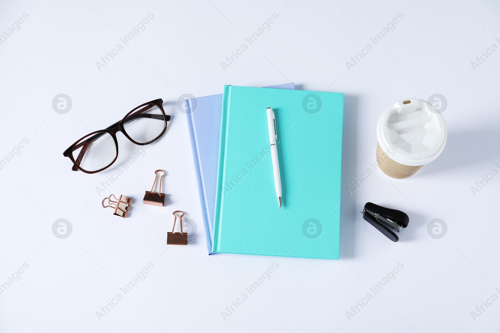 Flat lay composition with office supplies and takeaway paper cup on white table Photo of Flat lay composition with office supplies and takeaway paper cup on white table