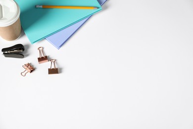 Photo of Office supplies and takeaway paper cup on white table, above view. Space for text