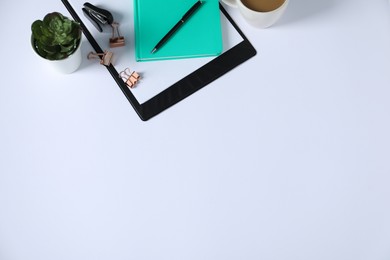 Photo of Office supplies and houseplant on white table, above view. Space for text