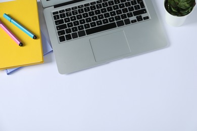 Photo of Office supplies, laptop and houseplant on white table, flat lay. Space for text