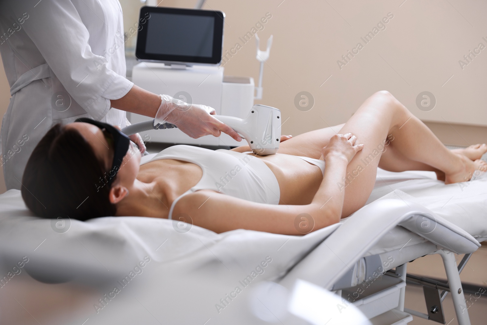 Woman during laser depilation procedure in beauty salon Photo of Woman during laser depilation procedure in beauty salon