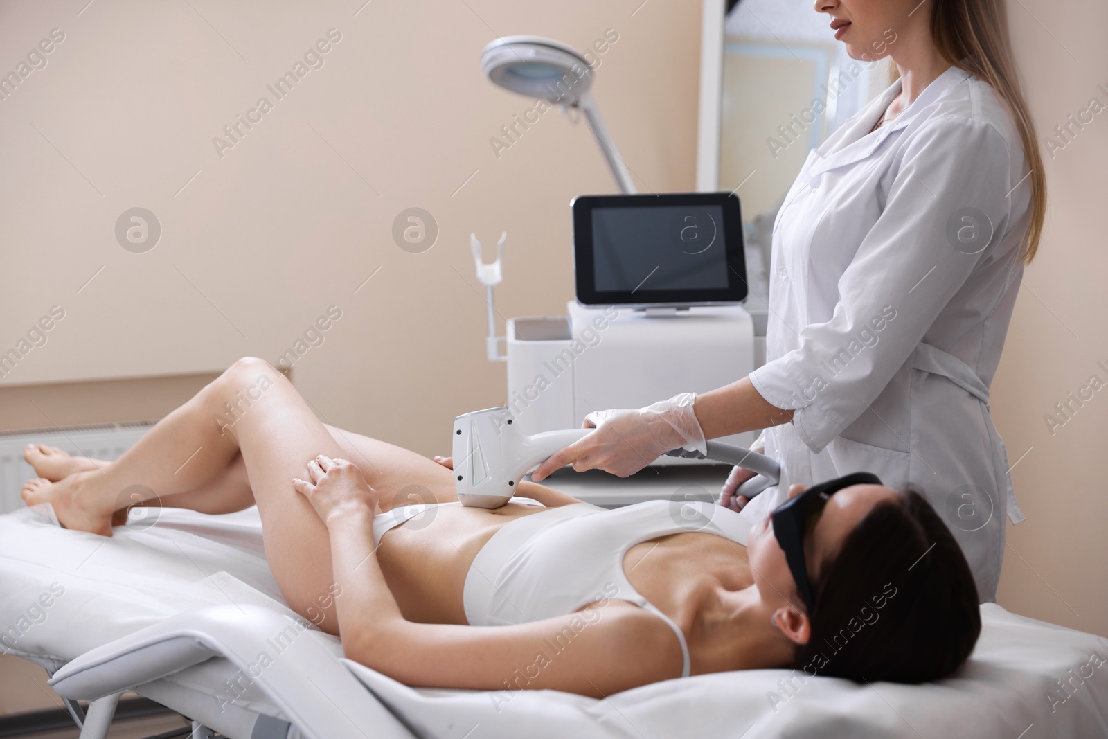 Woman during laser depilation procedure in beauty salon Photo of Woman during laser depilation procedure in beauty salon